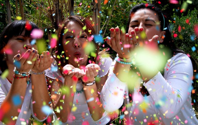 Women Celebrating Social Change Three women celebrate social change blowing coloured coloured confetti